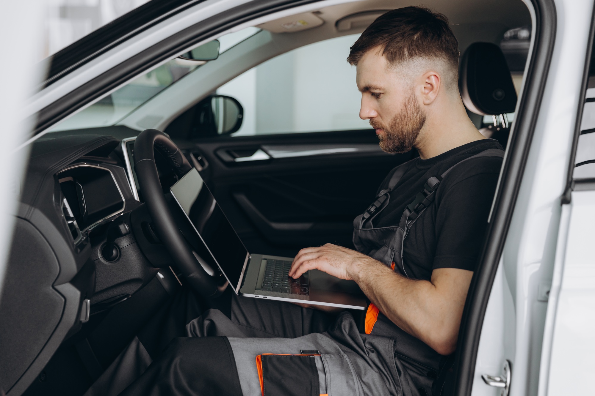 Automotive mechanic running diagnostics software on computer